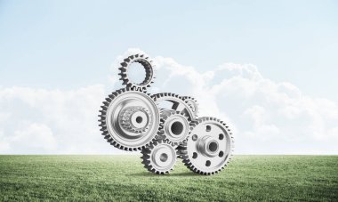 Yeşil çayır üzerinde cogwheels ile soyut mekanizma. İnşaat ve üretim. Mekanik teknoloji makine mühendisliği. Yeşil çimen ve mavi gökyüzü ile doğa manzara. 3b nesneile karışık ortam