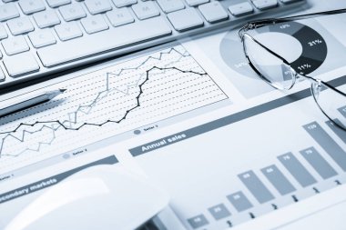 Klavye fareli iş yeri ve grafik ve diyagramlı kağıtlar