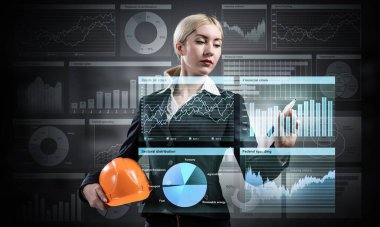 İş kadını 3D mali tablosunu işaret ediyor. Takım elbiseli kadın kaskıyla ayakta duruyor. Dijital teknoloji ve inşaat endüstrisinde yenilik. Ekonomi ve yatırım veri görselleştirmesi.