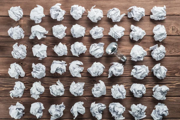 Bombilla Incandescente Bolas Papel Blanco Arrugadas Sobre Mesa Madera Marrón —  Fotos de Stock