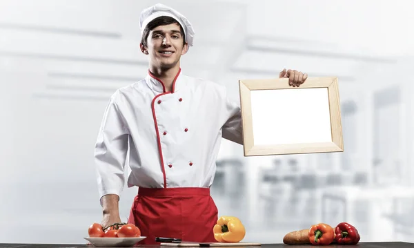 Jovem Chef Perto Mesa Cozinhar Segurando Placa Branca Branco Bonito — Fotografia de Stock