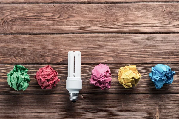 Bombilla Incandescente Bolas Papel Blanco Arrugadas Sobre Mesa Madera Marrón — Foto de Stock