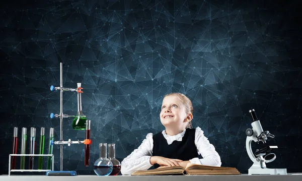 책상에 앉아서 여학생 해피걸 과학자 교실에서 공부하고 플라스크와 실험용 튜브가 — 스톡 사진