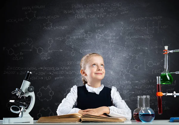 女学生坐在书桌前 打开书本 快乐的女科学家在教室里和黑板一起学习 带有玻璃瓶和试管的化学实验室 穿着校服看书的聪明女孩 — 图库照片