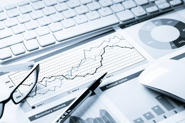 Klavye fareli iş yeri ve grafik ve diyagramlı kağıtlar