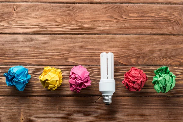 Bombilla Incandescente Bolas Papel Blanco Arrugadas Sobre Mesa Madera Marrón — Foto de Stock