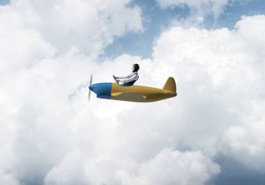Mutlu pilot bulutlar ile mavi gökyüzü nün arka planda küçük pervane uçak sürüş. Uçakla dünyayı dolaşıyor. Küçük bir uçakla uçan komik adam. Kabarık bulutlar ile Cloudscape arka plan.