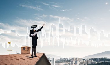 Evin çatısında baş durmak yerine kamerayla zum yapan yüzsüz iş kadını.