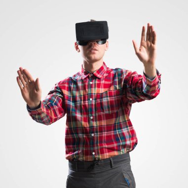 Ekose desenli gömlek gri arka plan karşı sanal kask giymiş genç adam