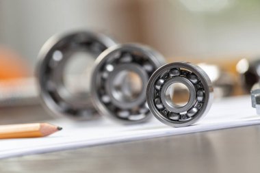Masada yatan üç farklı bilye. Otomotiv yedek parça satış şirketi. Ağır endüstri mühendislik şirketi. Makine tasarımı ve üretimi. Motor mekanizmaları için çelik ayrıntıları.