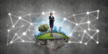 Uçan yeşil adada beton zeminde zarif bir iş kadını.