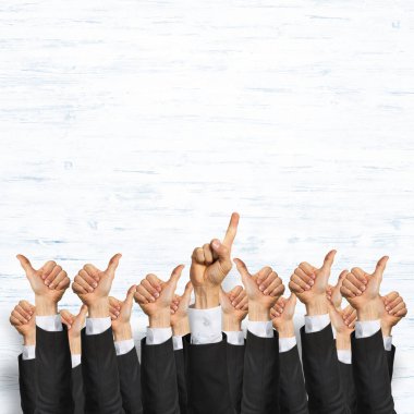 Bir grup iş adamı ahşap arka planda jestler gösteriyor.