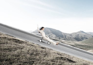 Dağ yolunda yokuş aşağı giden güzel, mutlu bir kadın. Beyaz takım elbiseli genç bir işçi dışarıda küçük bir bisiklete biniyor. Profesyonel kariyer başlangıcı. Çılgın şirket çalışanı eğleniyor..