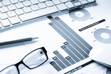 Klavye fareli iş yeri ve grafik ve diyagramlı kağıtlar