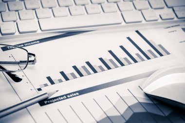 Klavye gözlüklü ve mali belgeleri masada olan iş yeri