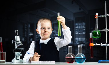 Küçük bilim adamı kız deney tüpünü kimyasal reaktörle inceliyor. Okulda araştırma ve eğitim. Mikroskop ve cam mataralı kimya laboratuvarı. Öğrenci kız kimya dersinde deney yapıyor.