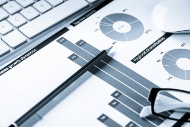 Klavye fareli iş yeri ve grafik ve diyagramlı kağıtlar
