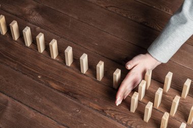 Dominoları tahta masaya düşmekten koruyan iş kadını. Kriz anında iş yardımı ve liderlik. Operatif iş çözümü ve durumun istikrar kazanması. Profesyonel risk yönetimi