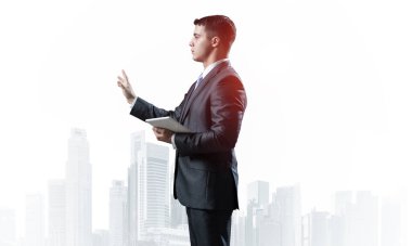 Arka plandaki sisli şehir manzarasında yönetici takım elbisesi ve kravat. Kendine güvenen bir işadamı fotokopi alanını işaret ediyor. Yükseltilmiş el promosyonu modeli olan bir finans uzmanı..