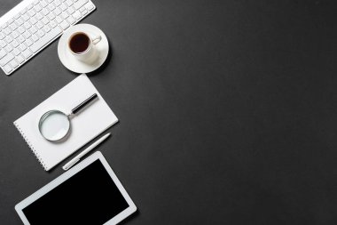 Tablet bilgisayarlı modern iş yeri manzarası. Düz siyah yüzey, fotokopi alanı ve bir fincan kahveyle yatıyordu. Profesyonel danışmanlık, denetim ve muhasebe. Dijital teknoloji ve mobil yaşam tarzı.