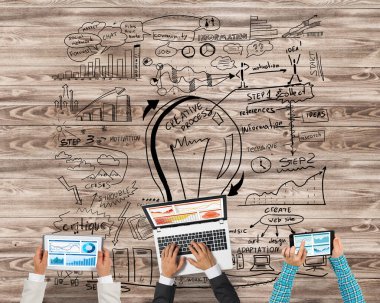 Ellerinde cihazlar bulunan üç kişilik bir grup iletişim ve ağ oluşturma sembolü olarak birlikte çalışıyor.