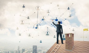 Delikanlı çatıda dikiliyor ve bağlantı hatları çiziyor. Karışık ortam