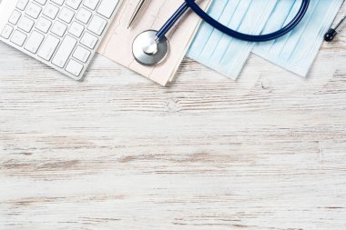 Modern hastanede tıbbi teşhisler. Bilgisayar klavyesi, steteskobu ve kardiyogramı olan üst düzey bir doktor masası. Rehabilitasyon terapisi konsepti. Profesyonel sağlık ve sağlık sigortası hizmeti