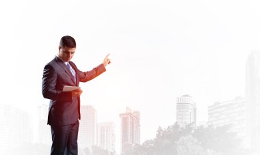 Arka plandaki sisli şehir manzarasında yönetici takım elbisesi ve kravat. Kendine güvenen bir işadamı fotokopi alanını işaret ediyor. Yükseltilmiş el promosyonu modeli olan bir finans uzmanı..
