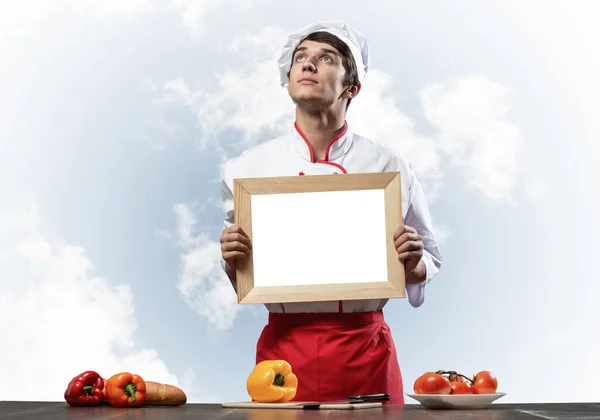 Jovem Chef Perto Mesa Cozinhar Segurando Placa Branca Branco Bonito — Fotografia de Stock