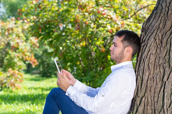 Jongeman Met Behulp Van Tablet Computer Onder Boom Het Park — Stockfoto