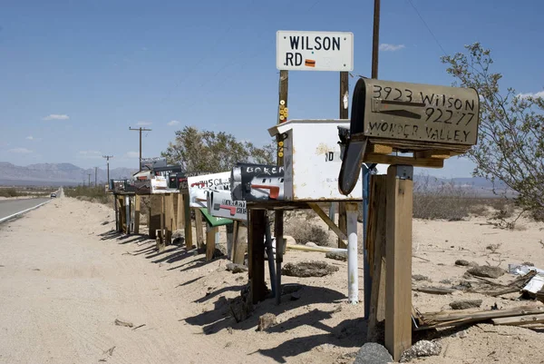 Caixas de correio americanas típicas ao lado da estrada do deserto empoeirada na Califórnia — Fotografia de Stock