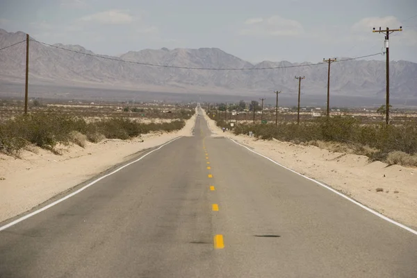 Longa estrada reta através da paisagem do deserto da Califórnia — Fotografia de Stock