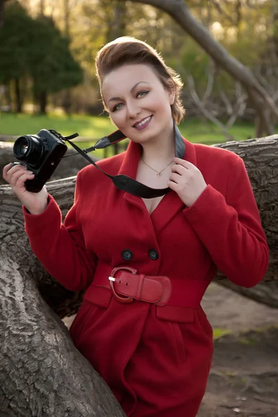 Fotógrafo mulher elegante no parque de pé sozinho e sorrindo — Fotografia de Stock