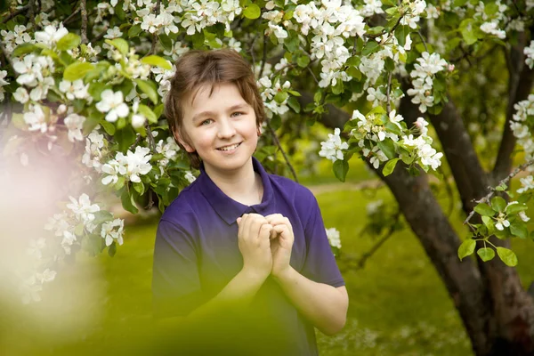 Niño bonito en el jardín de manzanas feliz con flores en la primavera — Foto de Stock