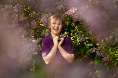 oldukça nazik çocuk onun avuç içi yaz bahçesinde tarafından leylak ağaçları ve gösteren sevgi kalp simgesi gülümseyen