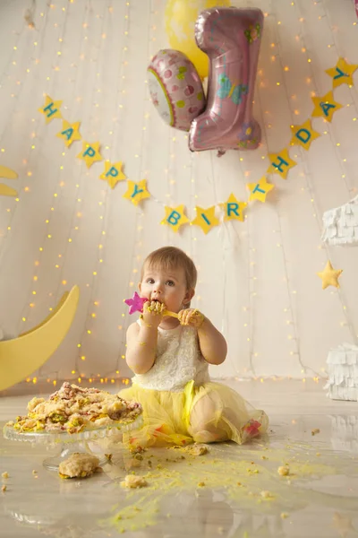 Pequeno bebê aniversário um ano menina esmagando seu bolo amarelo — Fotografia de Stock