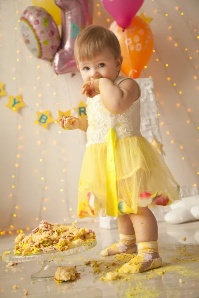 little baby birthday one year girl crushing her yellow cake