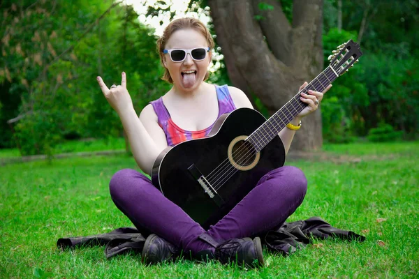 Όμορφη γυναίκα με μαύρη κιθάρα στο πάρκο — Φωτογραφία Αρχείου