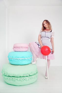 Beyaz arka plan Studio dev tatlılar oldukça genç bir bayanla polka dot PIN dress up