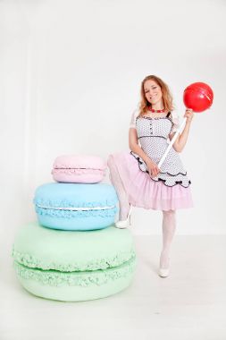 Beyaz arka plan Studio dev tatlılar oldukça genç bir bayanla polka dot PIN dress up