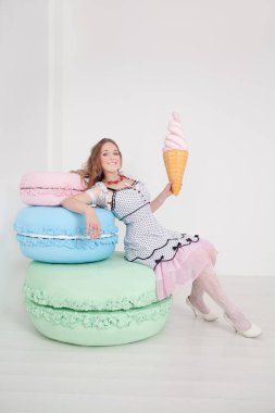 Beyaz arka plan Studio dev tatlılar oldukça genç bir bayanla polka dot PIN dress up