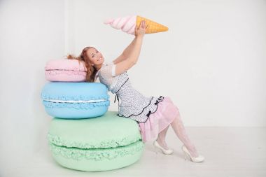 Beyaz arka plan Studio dev tatlılar oldukça genç bir bayanla polka dot PIN dress up
