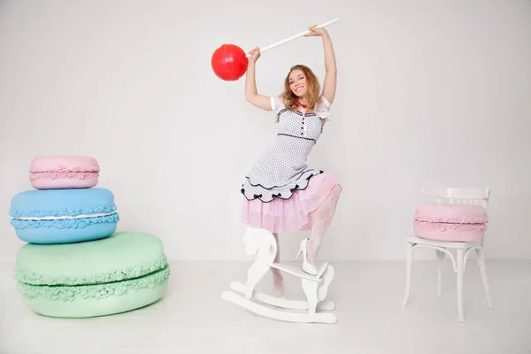 Graziosa giovane signora in polka dot pin up vestito con caramelle giganti in studio sfondo bianco — Foto Stock