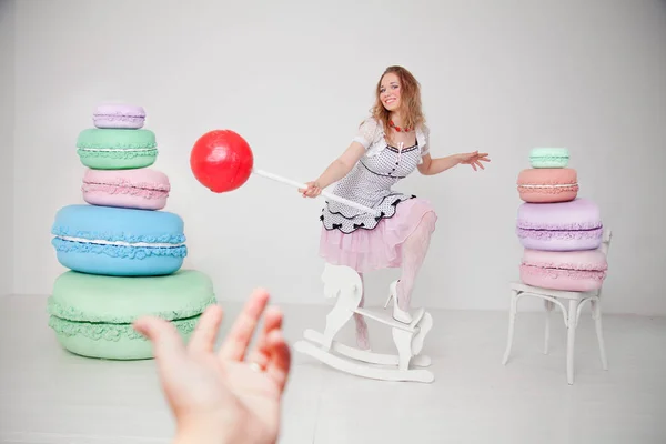 Jolie jeune femme à pois pin up robe avec des bonbons géants en studio fond blanc — Photo