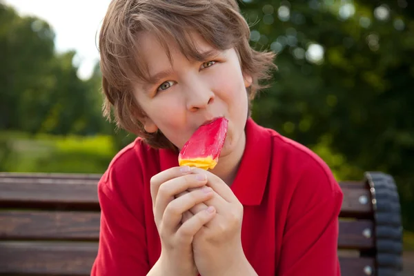 Είδος παιδί παιδί τρώει κόκκινο παγωτό στο πάρκο — Φωτογραφία Αρχείου