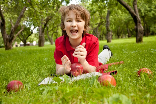 Έφηβος αγόρι διαβάζοντας ένα βιβλίο στο πάρκο δέντρα μήλο πράσινο το καλοκαίρι — Φωτογραφία Αρχείου