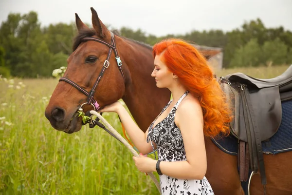 Orange hair woman and her brown horse in the field just relaxing in summer day — Stock Photo, Image