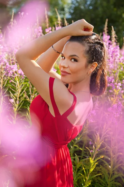 Ganska nöjd leende brunett kvinna på naturen i fältet rosa lila blommor — Stockfoto