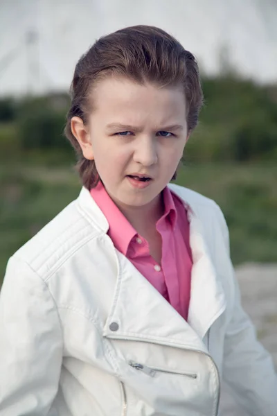 Coole weiße Kleidung Mode Kind Junge mit unhöflich brutalen Gesicht im Freien in der Nähe des großen Berges — Stockfoto