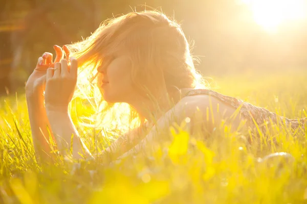 Trendiga Hipster smal tjej avkopplande på gräset i parken sommar solnedgång — Stockfoto